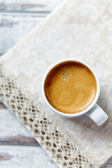 Cup of coffee on bright background. Top view.
