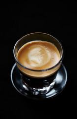 Coffee in glass cup on black background. Close up. 