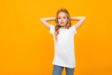 Nice little girl in white t-shirt gesticulating and smiles on camera isolated on white background