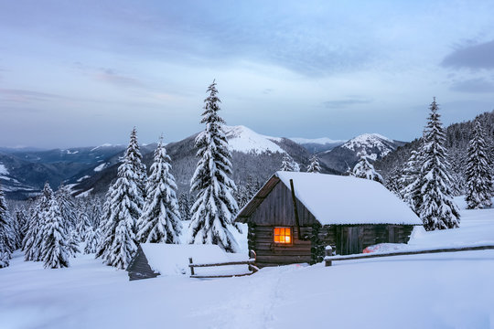 Fantastic winter landscape with wooden house in snowy mountains. Christmas holiday and winter vacations concept. Carpathians mountain, Ukraine, Europe