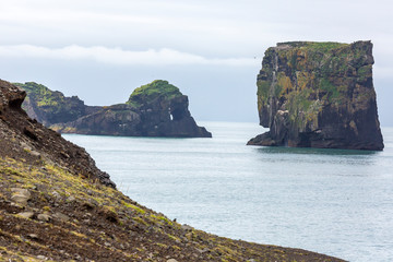 View on natural arches at Reynisfjara black beach in southern Iceland in summer