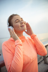 Happy lady listening to music through wireless headphones