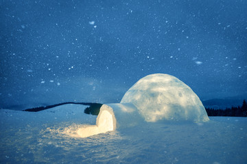 Wintry scene with snowy igloo and milky way in night sky. Fantastic winter landscape glowing by star light. Santa house from snow, ideal New Year and Christmas background - obrazy, fototapety, plakaty