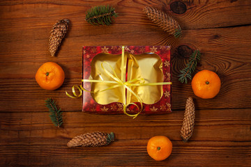 Christmas gift in golden pouch bags, red present box wrapped with New year decorations on rustic wooden background. Trendy tea,coffee packaging mockup, flatlay style.Copy space,winter holidays concept