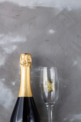Wineglasses and bottle of champagne on grey background. Flat lay for christmas celebration concept.