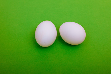 White chicken eggs are on green background. Easter card greeting. Flat lay. Copy space.