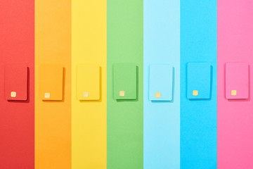 top view of multicolored empty credit cards on rainbow background