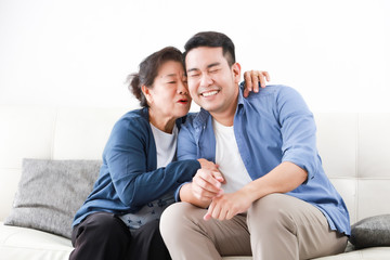 Asian senior mother in blue shirt  kiss her son happy and smile face in living room - 309179231