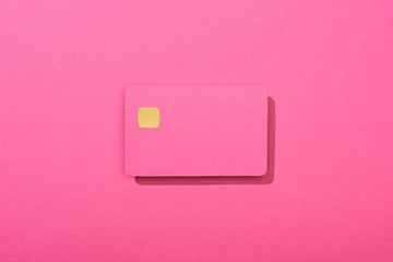 top view of colorful empty credit card on pink background