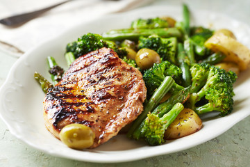 Grilled Turkey Breast with oven baked potatoes and broccoli. Bright  wooden background. Close up. 