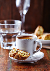 Cup of coffee with cantuccini  (Italian cookies) on rustic wooden background. 