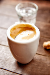 Cup of coffee on brown wooden background. Close up.
