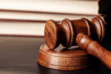 Wooden gavel and juridical books close up