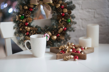 Christmas morning. Christmas toys, cup of coffee and christmas wreath on a white wooden table....