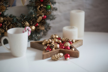 Christmas morning. Christmas toys, cup of coffee and christmas wreath on a white wooden table....