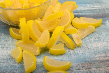 Marmalade lemon slices on wooden background. Sweet dessert. Close up.