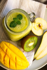 green smoothie in a glass and fruits