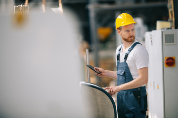 Man with helmet working in factory.