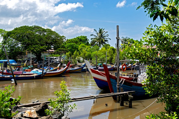 Obraz premium Beautiful rural scenery, fisherman boat moored near wooden jetty over blue sky background
