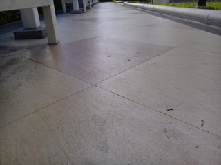 Brown ceramic tiles walkway and lawn in the park.