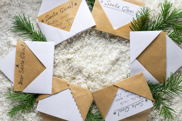 Christmas letters and envelopes to Santa Claus on Kraft paper, fir twigs and garlands top view