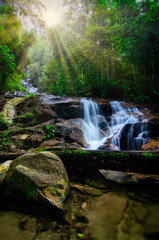 Beautiful tropical waterfall in lush surrounded by green forest.wet rock and moss.selective focus shot.