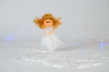 Christmas angel with a star in his hands, delicate and beautiful on a light background