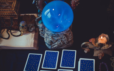 Tarot cards and crystal ball, candles, witch magic bottles . Wicca, esoteric, divination and occult background with vintage magic objects for mystic rituals