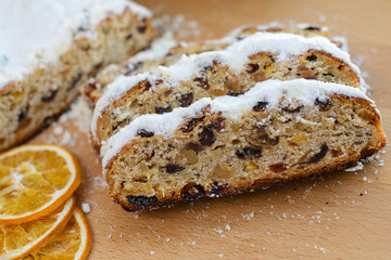 Stollen traditional german christmas baking. With raisins and candied fruit, sprinkled with powdered sugar. Tasty homemade sweets. Close-up selective focus. Free baking recipes ideas.