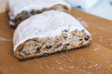 Stollen traditional german christmas baking. With raisins and candied fruit, sprinkled with powdered sugar. Tasty homemade sweets. Close-up selective focus. Free baking recipes ideas.