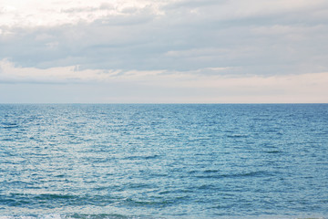 View of Barcelona beach, in the Barceloneta district, overlooking the Mediterranean Sea. The sky is dark and there are many waves.