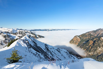 Snowy hills and mountains above fog in winter. Allgau Alps, Bavaria, Germany