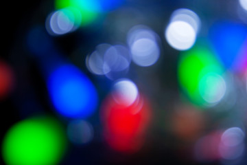 Blurred christmas lights dark blue, white, red, pink, green background. Abstract bokeh with soft light. Shiny festive texture