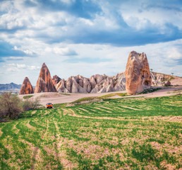 Off road traveling among the vierd forms of limestone peaks in Cappadocia. Wonderful morning view of Red Rose valley. Cavusin village located, district of Nevsehir, Turkey, Asia.