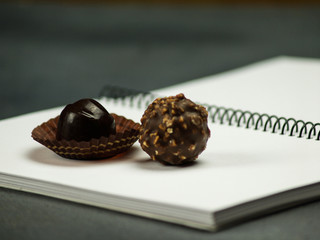 Naklejka premium Chocolate bonbons on a spiral notebook