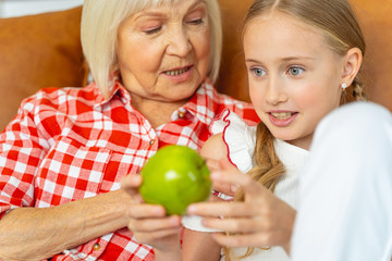 Fototapeta premium Serious senior woman gazing at her granddaughter