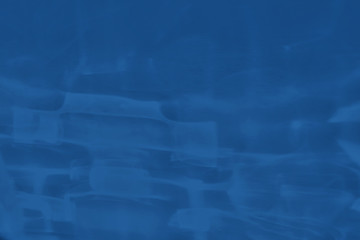 Trendy blue colored low contrast abstract background with light and shadows caustic effect. Light passes through a glass. Water background. 2020 year color trend