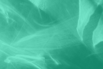 Trendy mint colored abstract background with light and shadows caustic effect. Light passes through a glass. 2020 year color trend. Water background. 