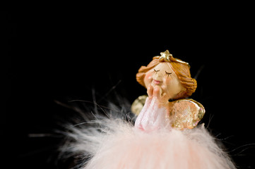 Toy Christmas angel, delicate and beautiful on a dark background