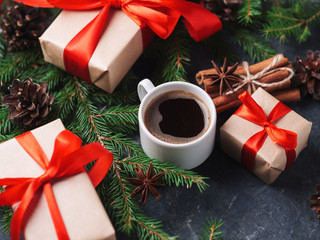 A Cup of coffee on the holiday table and gift boxes Packed in Kraft paper and red ribbon