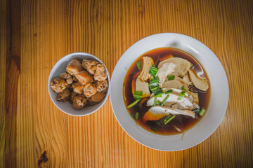 Chicken noodles soup in bowl at noodle shop street .	