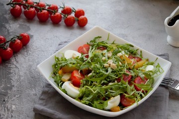 Healthy vegetable salad with cherry tomatoes, arugula, egg, caramelized pear and nuts. Vegetable salad with sauce. Salad with dressing. Salad with an egg. Salad with pear. Vegetarian