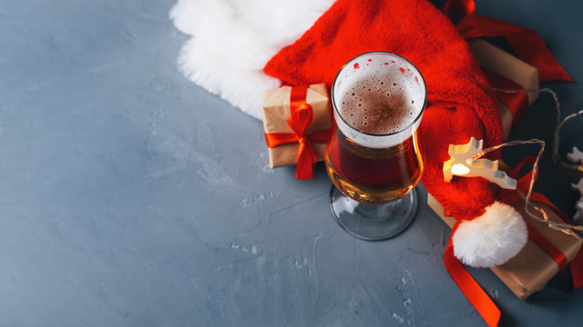 Festive new year and Christmas glass of light beer on the table with gifts copy space