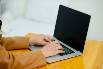 Woman using a laptop, searching the web, browsing information, having a workplace at home Doing business online at home. Online business concepts