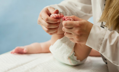 Mother love Mother holding her little baby's feet, close up.Concept skin examination by a doctor