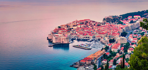 Pink morning light glowing sleeping Dubrovnik city. Panoramic summer view of Adriatic sea, Croatia, Europe. Beautiful world of Mediterranean countries. Traveling concept background.