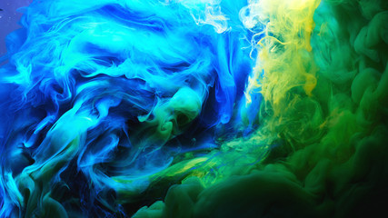 Abstract dancing colorful fume background. Clouds of smoke blue, green and yellow, a whirlwind of...
