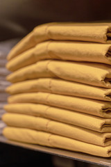 a stack of clothes in the store, pullovers and sweatshirts nicely and neatly stacked in bundles on the table, yellow mustard and sand color close up