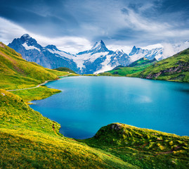 Naklejka na ściany i meble Dramatic summer view of the Bachalpsee lake with Schreckhorn peak on background. Picturesque morning scene of Swiss Bernese Alps, Switzerland, Europe. Beauty of nature concept background.