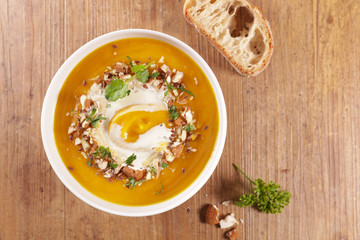 pumpkin soup with cream and nuts in bowl